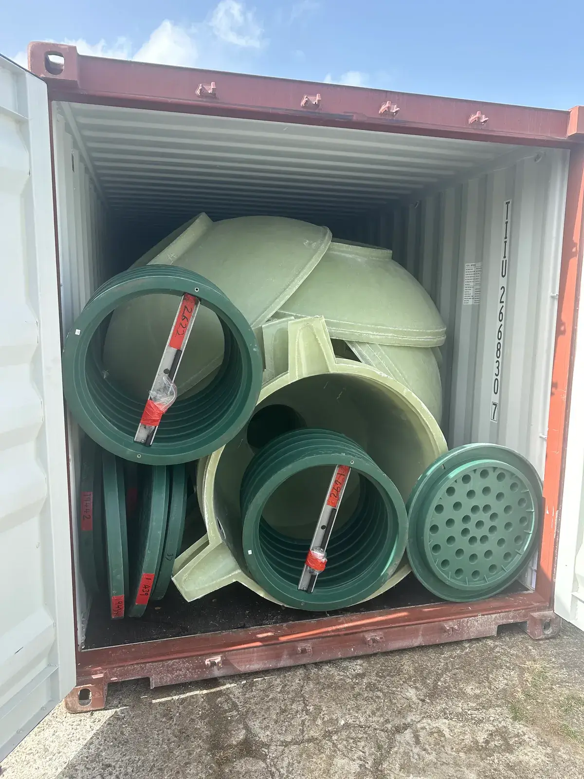 Conteneur ouvert, rempli de pièces moulées en PRV vert clair et de rehausses vertes