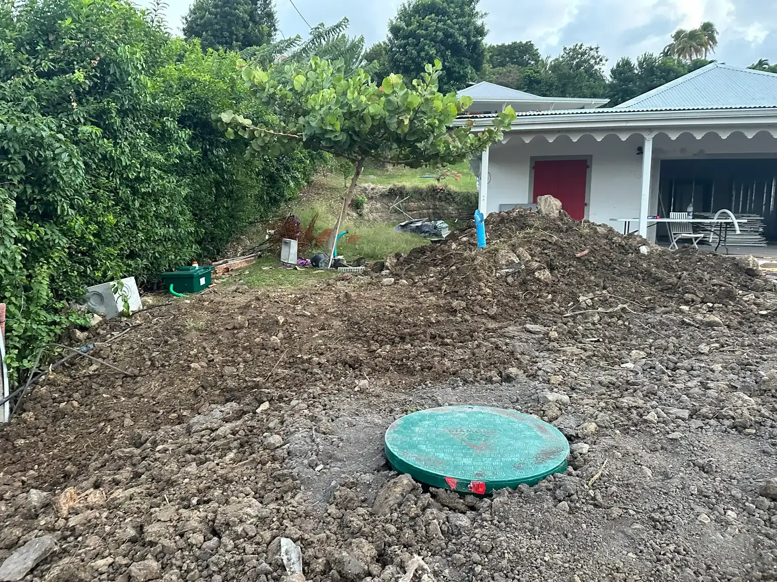 Le même terrain remblayé devant la maison, le couvercle vert de la cuve au ras du sol