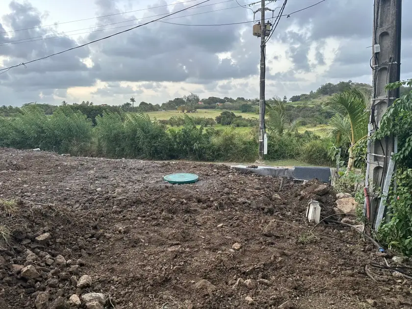 Le terrain remblayé, le couvercle vert de la cuve au milieu, avec vue sur la campagne