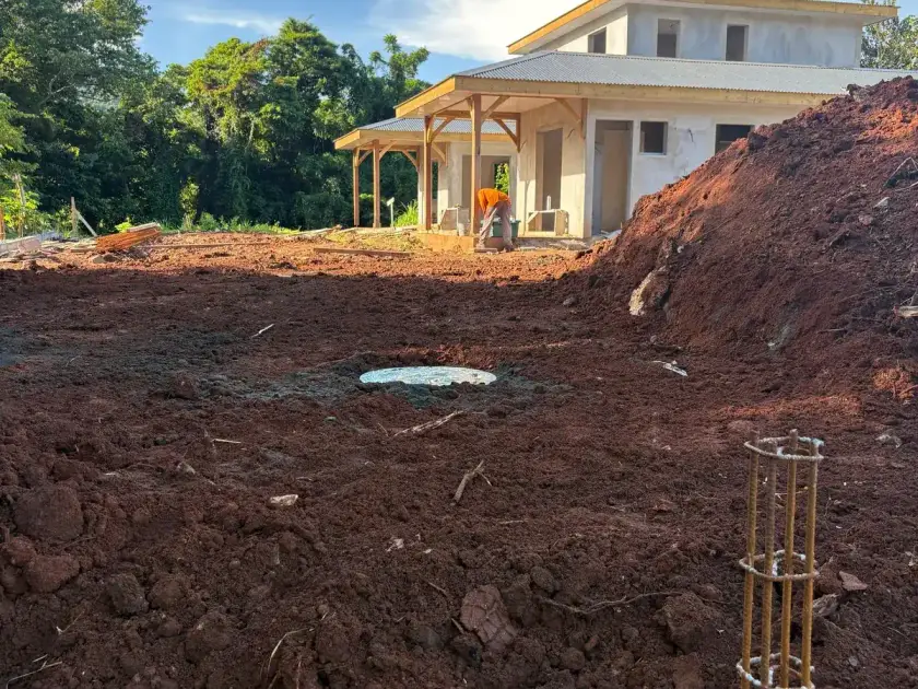 Maison à étage en construction, couvercle de cuve au milieu du terrain fraîchement terrassé