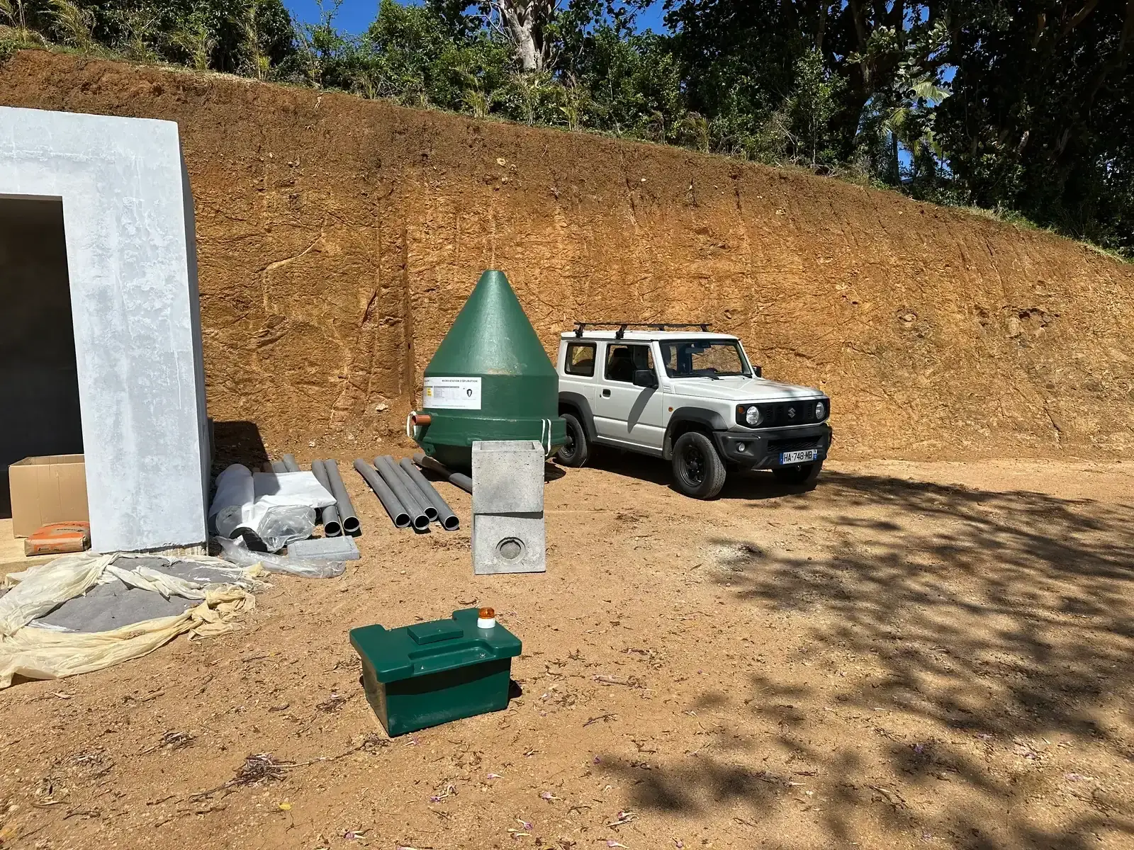 Micro-station Diamond verte livrée sur un terrain, à côté des tuyaux et du matériel de pose