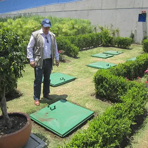 Station AQUAMAX enterrée dans un jardin au Mexique : des couvercles verts au milieu des haies